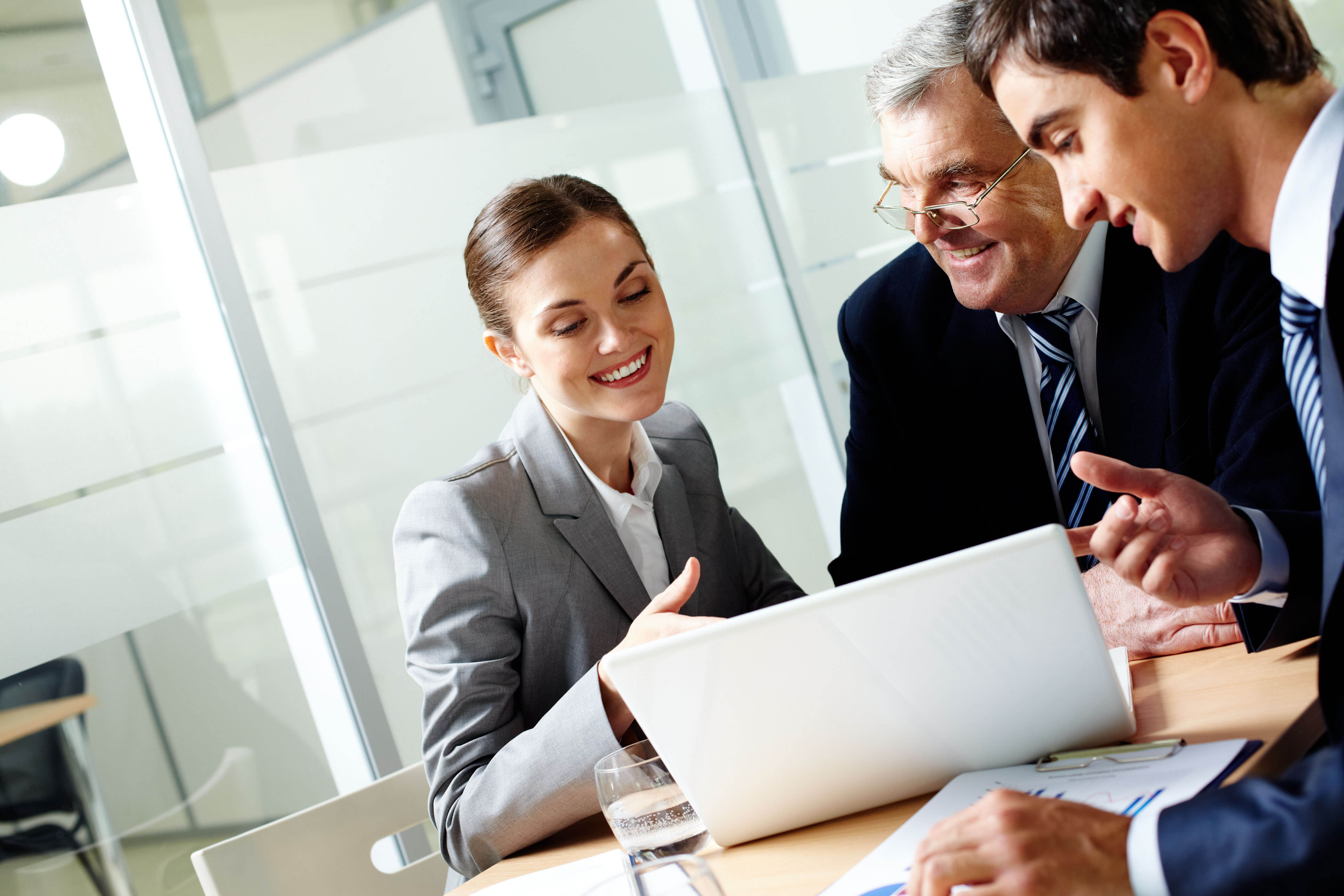 Colleagues smiling while working together on a laptop