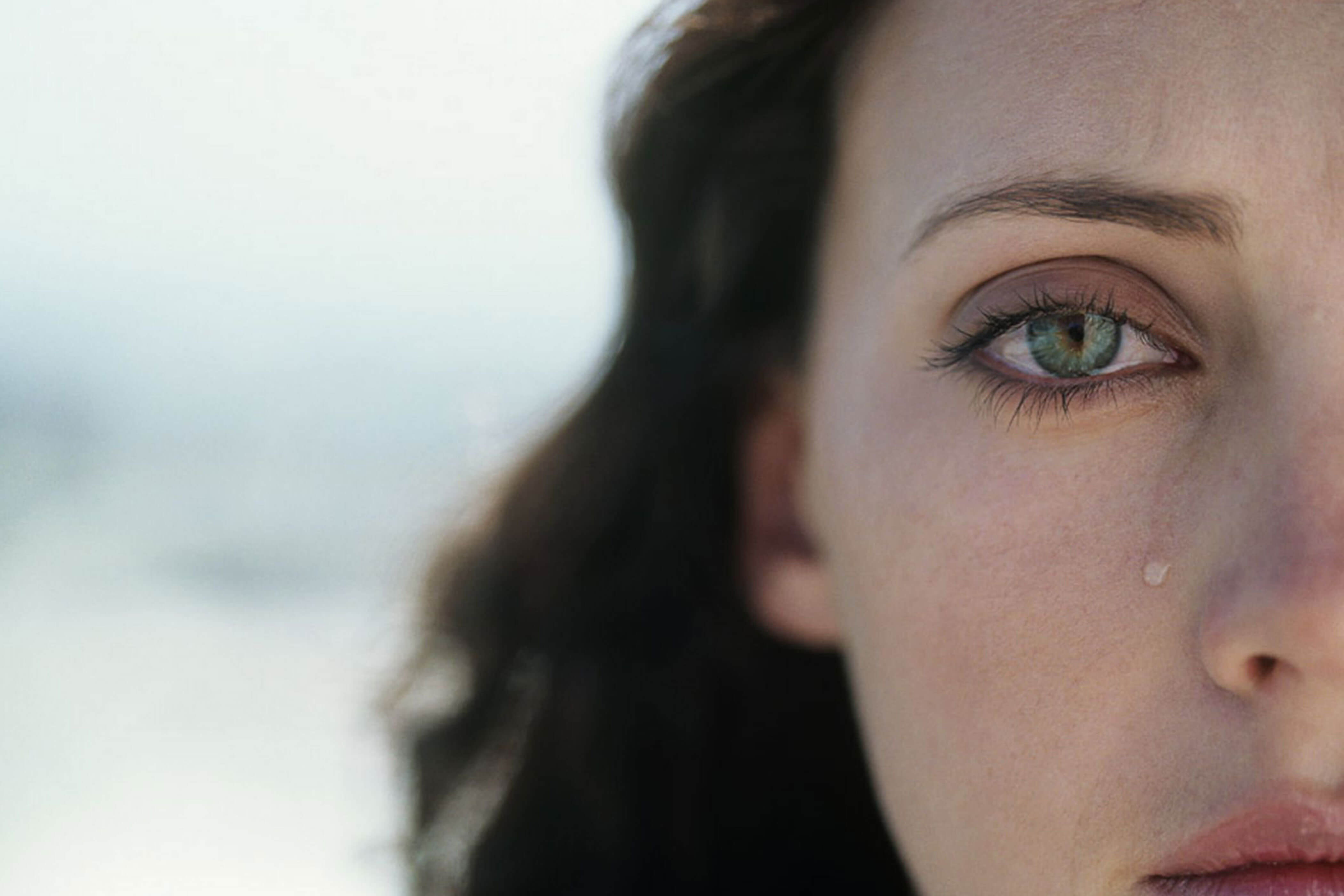 Close-up of a woman with a tear on her cheek